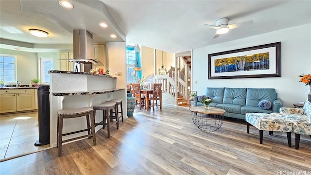 living room featuring sink, ceiling fan, and light hardwood / wood-style flooring