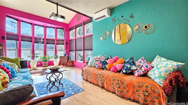 bedroom featuring multiple windows, a wall mounted AC, a textured ceiling, and light hardwood / wood-style flooring