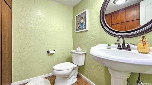 bathroom with toilet and tile patterned floors