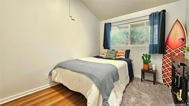 bedroom featuring hardwood / wood-style flooring, lofted ceiling, and a textured ceiling