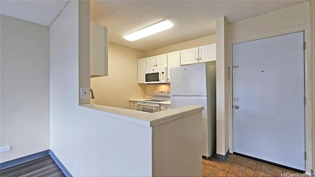 kitchen featuring white cabinetry, white appliances, kitchen peninsula, and a textured ceiling