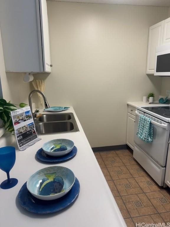 kitchen with sink, white appliances, and white cabinets