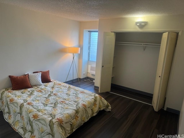 bedroom with a closet, dark hardwood / wood-style floors, and a textured ceiling