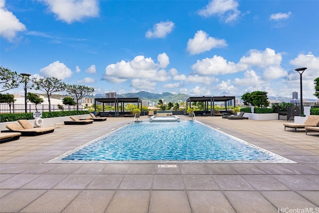 view of swimming pool featuring a patio and a mountain view