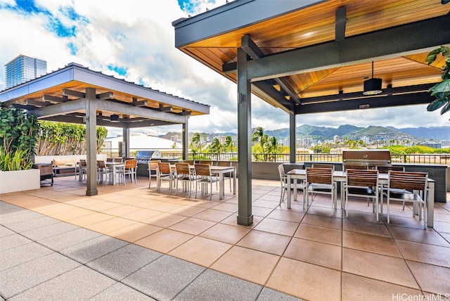 view of patio featuring a bar, a mountain view, a gazebo, and a grill