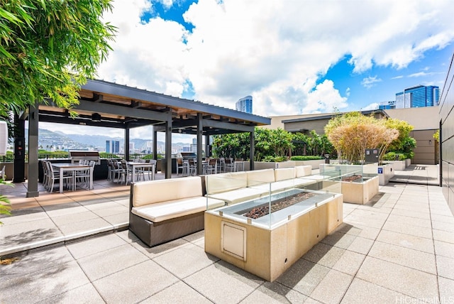 view of patio featuring a gazebo, a mountain view, and an outdoor living space with a fire pit