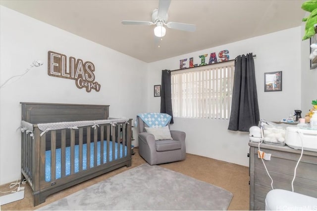 bedroom with ceiling fan and a nursery area