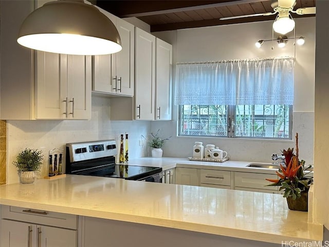 kitchen with beamed ceiling, decorative backsplash, electric stove, sink, and wooden ceiling