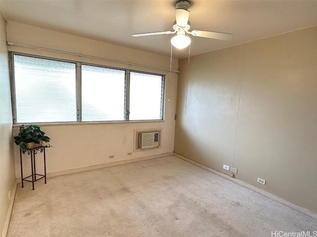 spare room featuring light carpet, ceiling fan, and an AC wall unit