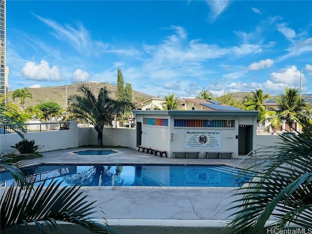 community pool featuring a patio, fence, and a mountain view