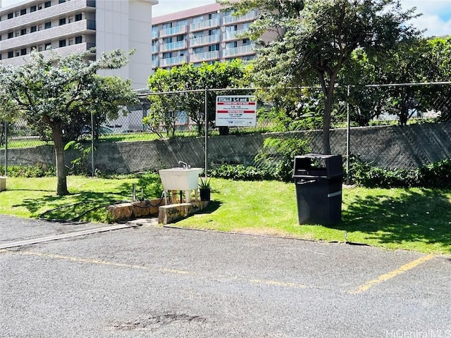 exterior space with uncovered parking, fence, and a yard