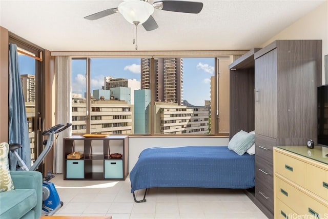 bedroom with ceiling fan and a textured ceiling