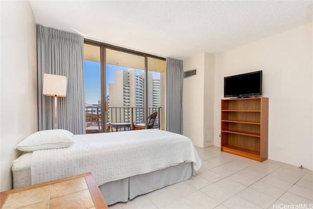 bedroom with floor to ceiling windows, access to exterior, a textured ceiling, and light tile patterned flooring