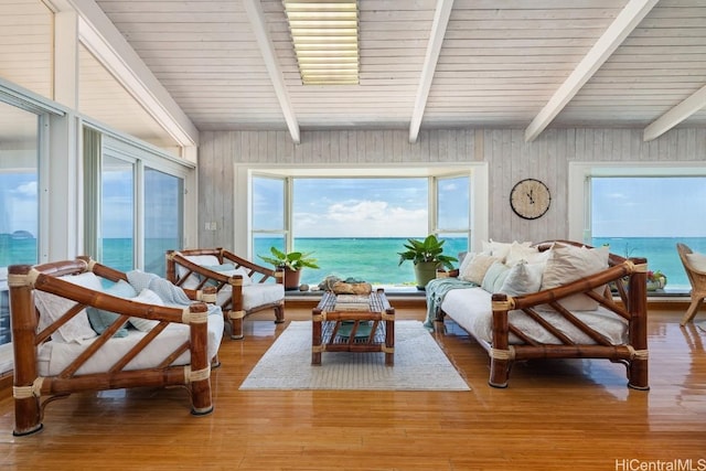 sunroom / solarium featuring beam ceiling and a water view