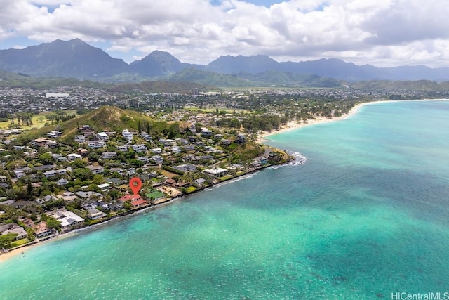 birds eye view of property with a water and mountain view and a beach view