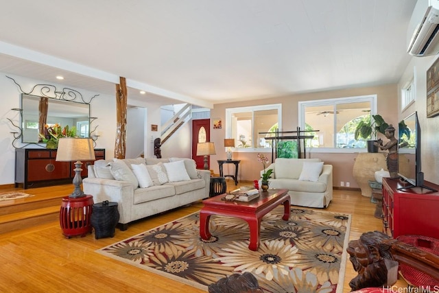 living room with a wall mounted AC and hardwood / wood-style floors