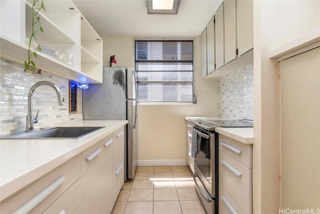 kitchen featuring sink, light tile patterned floors, decorative backsplash, and electric stove