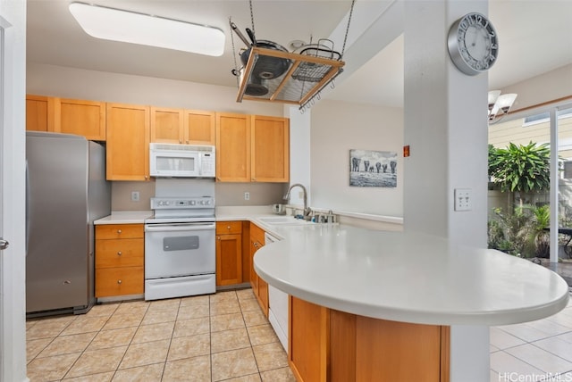 kitchen featuring kitchen peninsula, white appliances, sink, and light tile patterned floors