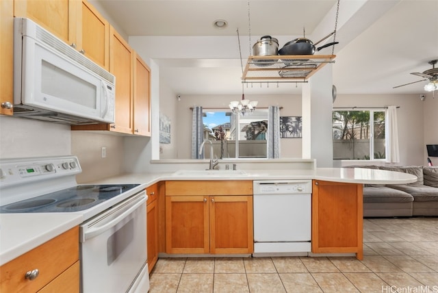 kitchen featuring ceiling fan with notable chandelier, white appliances, sink, kitchen peninsula, and light tile patterned floors