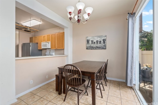 dining space with a notable chandelier and light tile patterned flooring