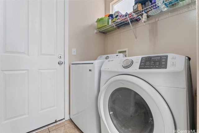 laundry area with light tile patterned floors and washer and dryer