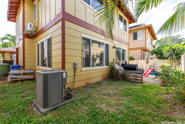 view of side of home with a lawn, central air condition unit, and a patio