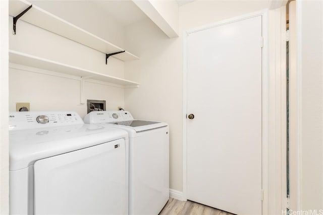 laundry area with light wood-type flooring and washing machine and clothes dryer