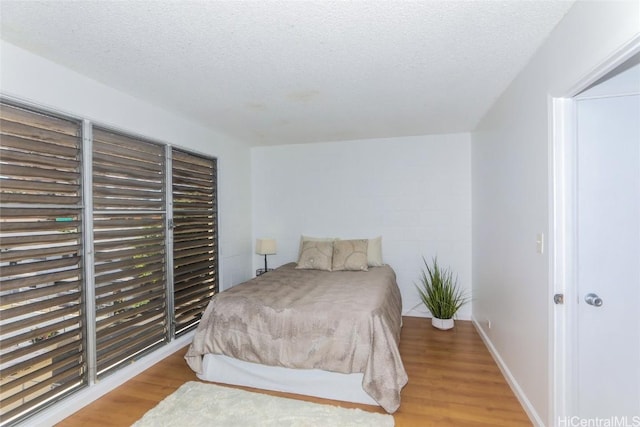 bedroom featuring a textured ceiling and light wood-type flooring