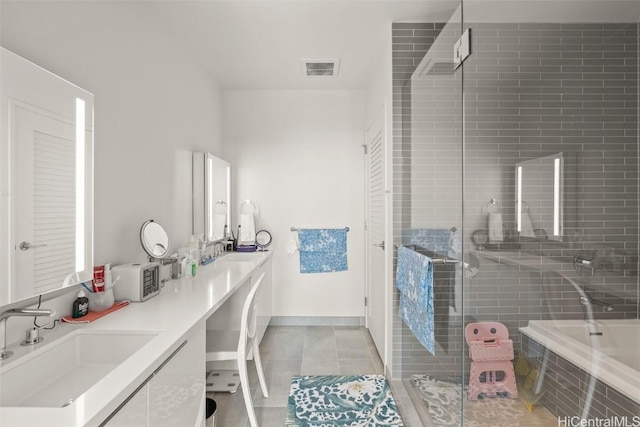 bathroom with double vanity, a stall shower, a sink, and tile patterned floors