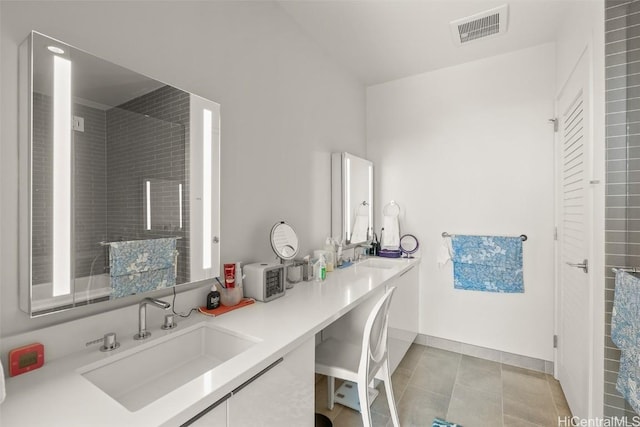 full bathroom with a sink, visible vents, baseboards, tile patterned floors, and double vanity