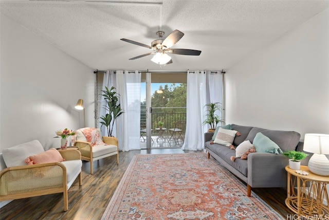 living room with ceiling fan, floor to ceiling windows, dark hardwood / wood-style floors, and a textured ceiling