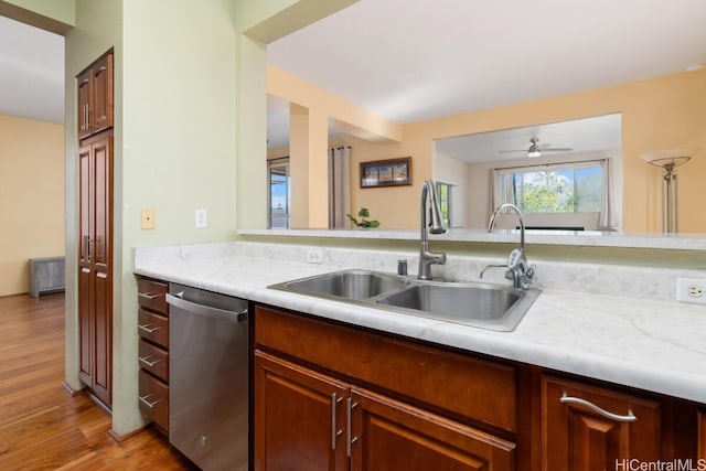 kitchen featuring ceiling fan, sink, dishwasher, and light wood-type flooring