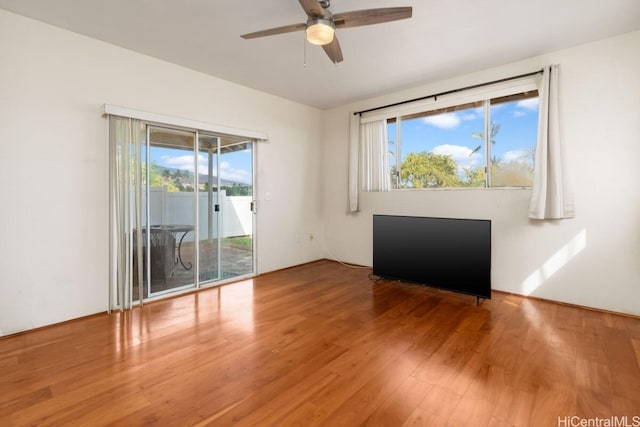 spare room featuring ceiling fan, plenty of natural light, and hardwood / wood-style floors