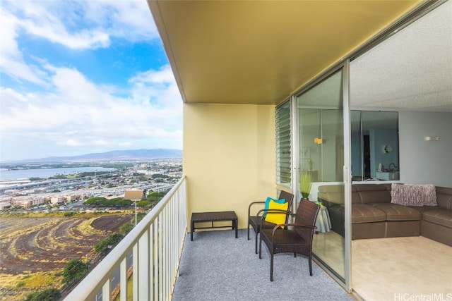 balcony featuring a water and mountain view