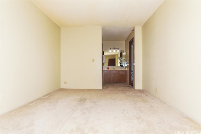 spare room with light colored carpet and sink