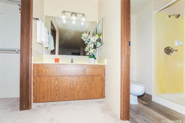 bathroom featuring vanity, a shower, and toilet