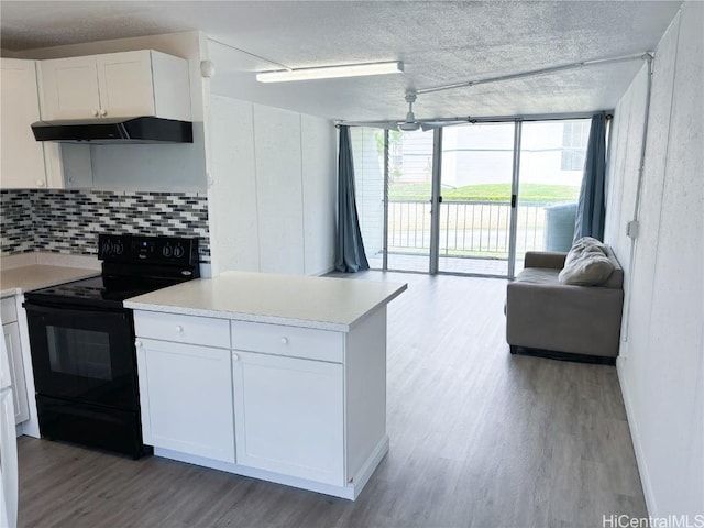 kitchen with a wall of windows, tasteful backsplash, electric range, white cabinets, and light hardwood / wood-style flooring