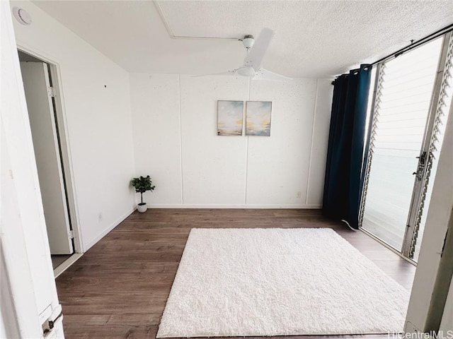 unfurnished room with lofted ceiling, ceiling fan, wood-type flooring, and a textured ceiling