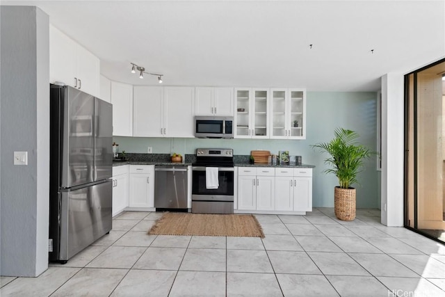 kitchen with white cabinetry, light tile patterned floors, and stainless steel appliances