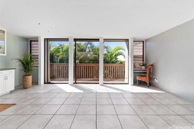 interior space with expansive windows and light tile patterned flooring