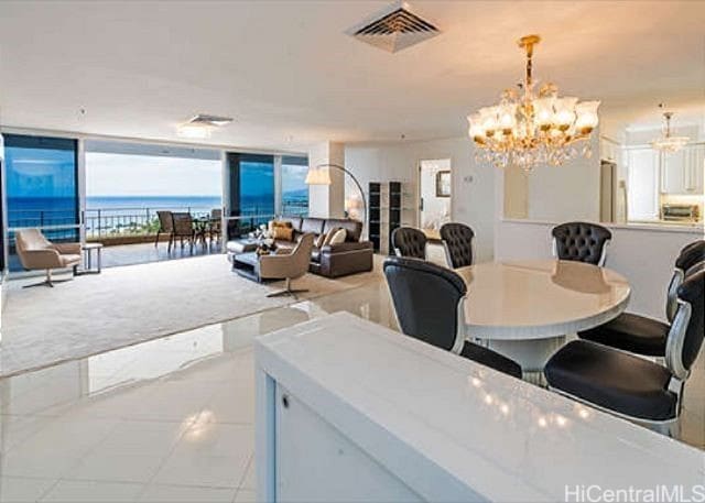 dining area with floor to ceiling windows, a water view, and a notable chandelier