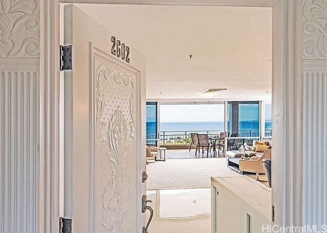 doorway to outside featuring a water view and expansive windows