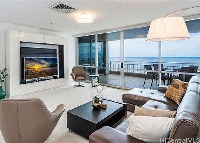 living room featuring a wall of windows and a water view