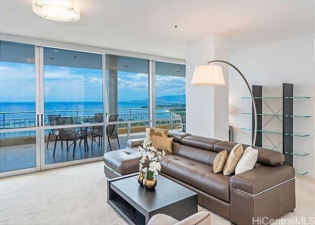 living room featuring floor to ceiling windows and a water view