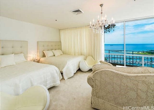 bedroom featuring carpet, a notable chandelier, access to outside, and a water view