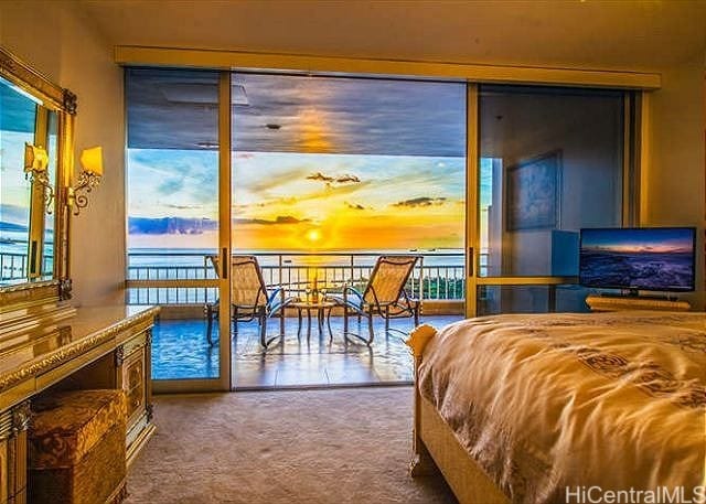 carpeted bedroom with a water view