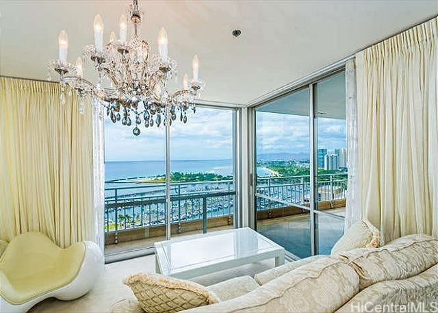 interior space with a water view, a notable chandelier, and floor to ceiling windows