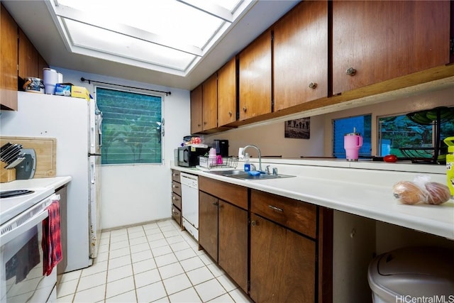 kitchen with sink, white appliances, and light tile patterned flooring