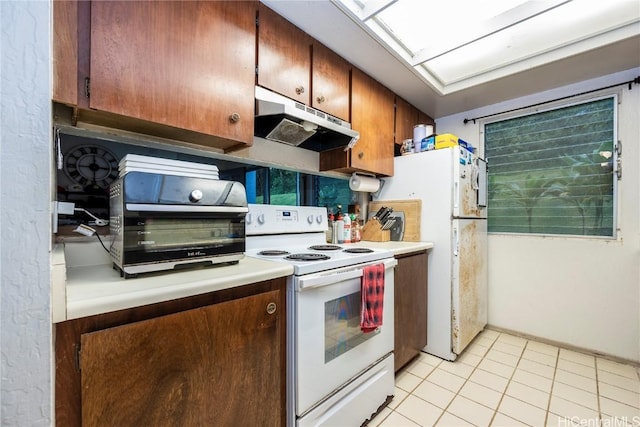 kitchen featuring light tile patterned floors and white appliances