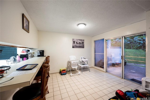 interior space featuring a textured ceiling and light tile patterned floors